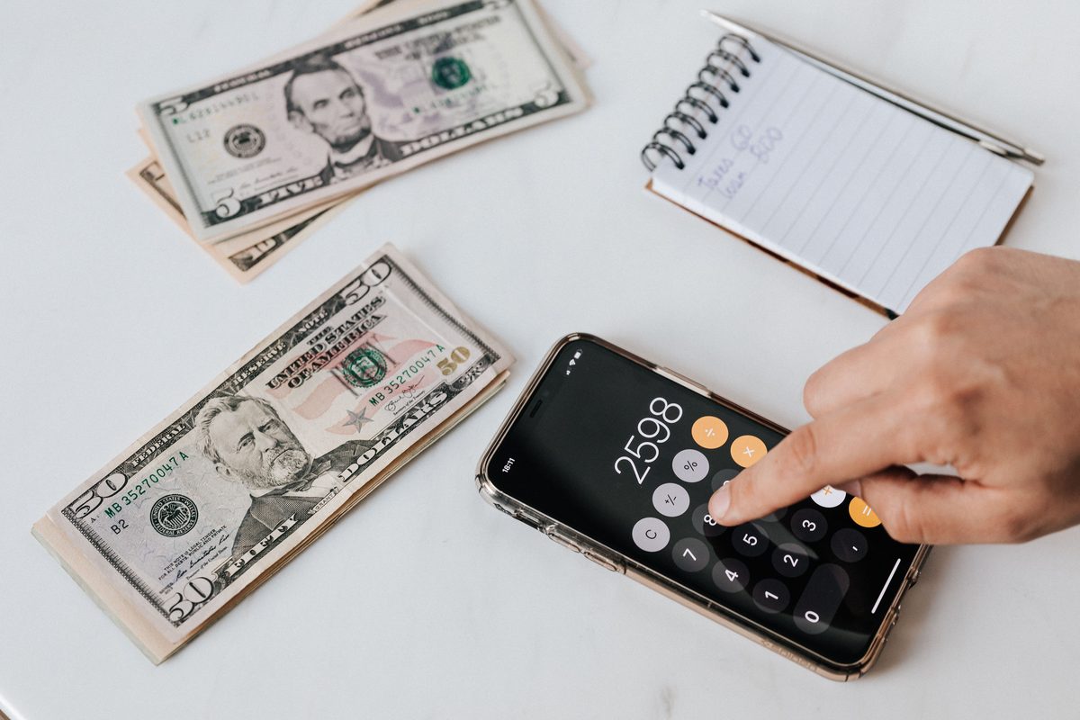CC Connect installment loan — calculator showing $2,598 loan repayment estimate with cash and notepad for personal finance planning
